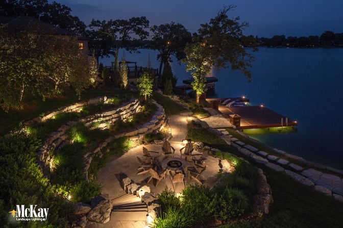 This lake home located in Beaver Lake, Nebraska utilizes several different lighting techniques to illuminate the outdoor fire pit area, dock, and seawall. Click to see more lake home lighitng ideas... | McKay Landscape Lighting, Omaha Nebraska