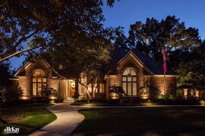 Landscape lighting makes the American flag a strong focal point at night adding interest and color. Click to read more about flag lighting requirements & tips | McKay Landscape Lighting Omaha Nebraska