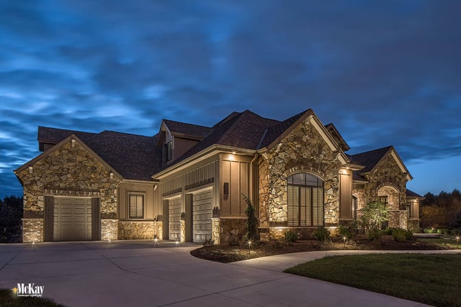 The garage is a prominent portion of the home. Lighting this area helps create balance and it's an easy way to add unique curb appeal. Additionally, a potential intruder could see a dark garage as an opportunity. | Learn more about this garage lighting design by McKay Landscpae Lighting