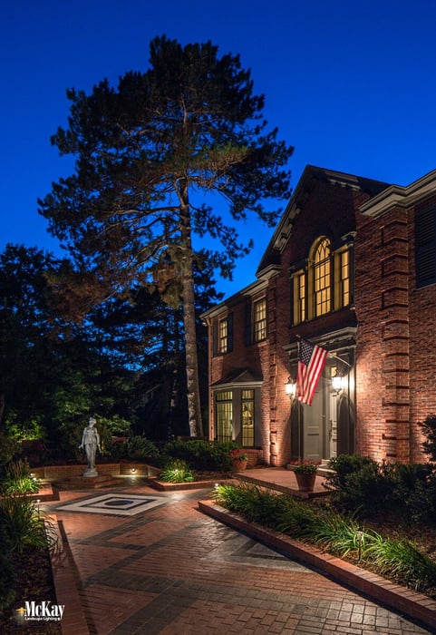 Low-voltage LED landscape lighting creates a subtle and noticeable impact as required by the flag code without overpowering the American flag. Learn more about the American flag lighting requirements. | McKay Landscape Lighting Omaha Nebraska