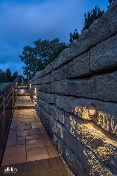 Retaining Wall Outdoor Lighting: These wall lights sit flush with the stone and effectively spread light down and out to light the path. The elevation changes as you walk. We installed a light at each step tread to help note each change in elevation. Click to learn more... | McKay Landscape Lighting - Omaha Nebraska
