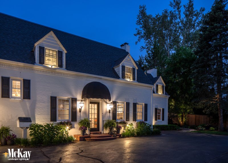 elegant outdoor uplighting on a classic white brick home